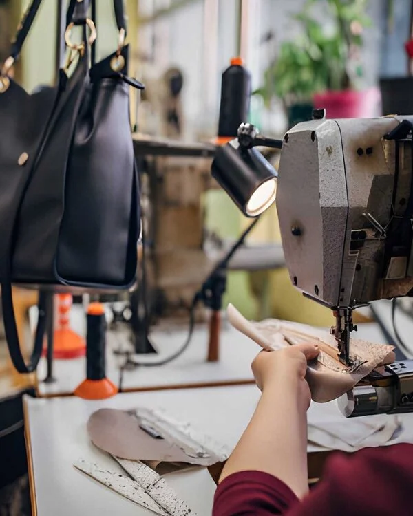 Worker Sewing Leather Handbag in Schott Leather Company