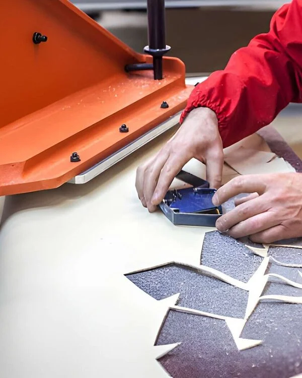 Worker cutting Leather Gloves on Press
